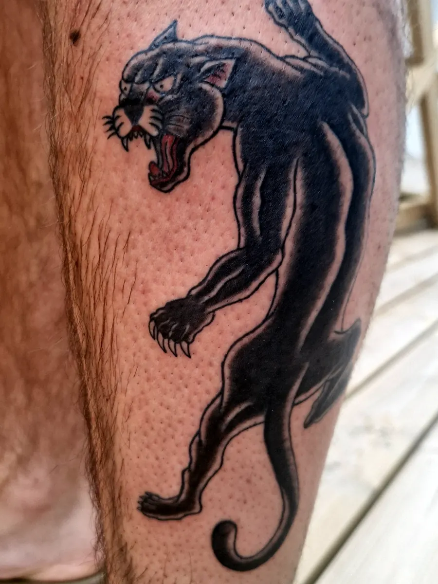 Black panther tattoo on a leg.