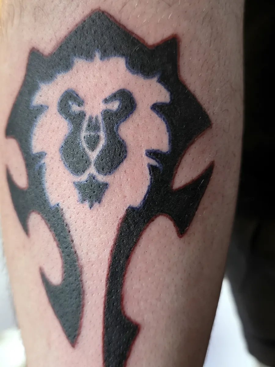 Dark abstract tattoo on the upper arm.