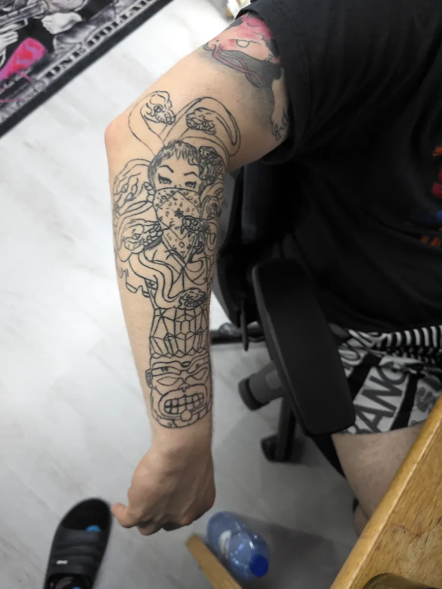 Side view of a large detailed arm tattoo.