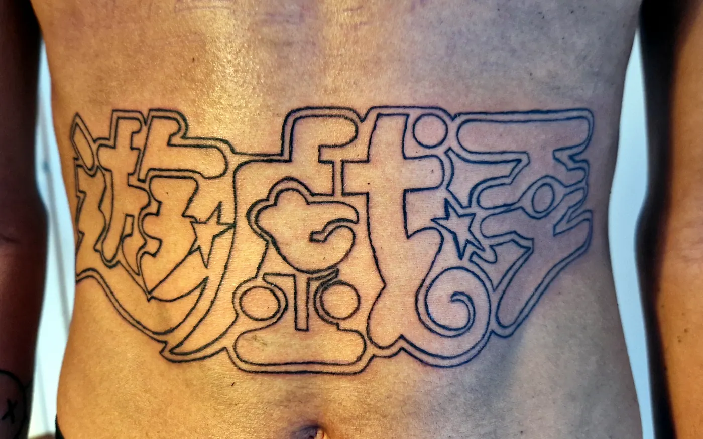 Large outline tattoo across the stomach.